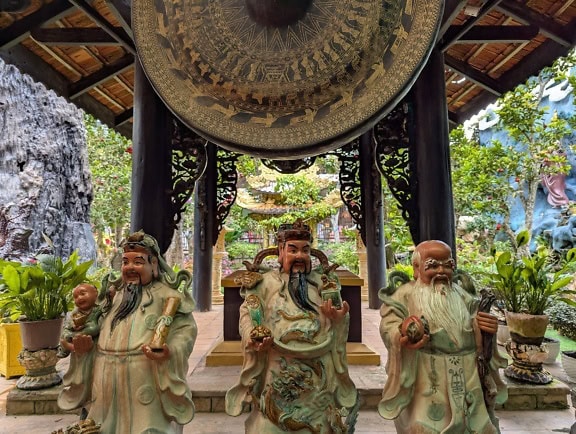 Sochy tří mudrců pod altánem s velkým gongem, buddhistický chrám, Vietnam