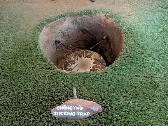 En cirkelfælde med forhindringer, der blev brugt under Vietnamkrigen, Cu Chi Tunnel Museum i Ho Chi Minh, Vietnam