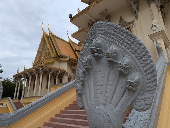 Statua di pietra alla scala di fronte a un edificio del Palazzo Reale della Cambogia, Phnom Penh