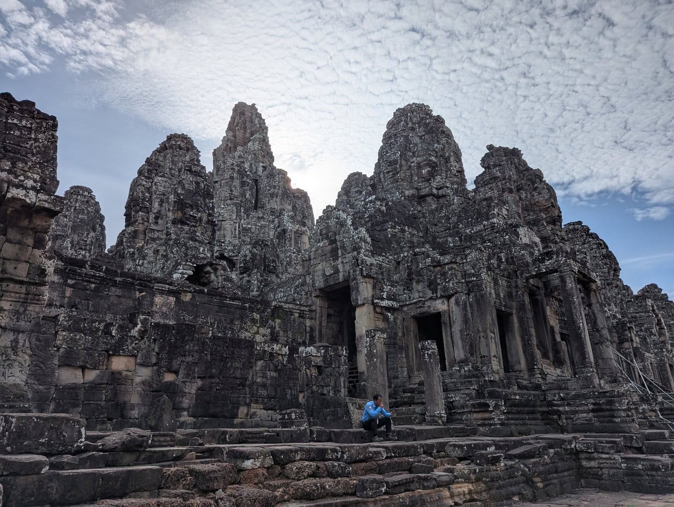 A Bayon templom kőlépcsőjén ülő személy, az Angkor Wat vallási komplexum része, Kambodzsa