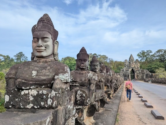 Az ősi szobrok remekműve buddhista kőszobrok fejjel az út mellett, Siem Reap, Angkor Wat, Kambodzsa