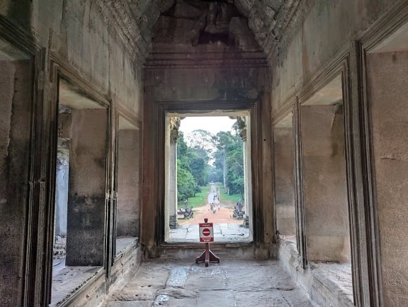 Muinaisen kivirakennuksen sisustus, jonka keskellä on punainen kyltti, Angkor Wat, hindu-buddhalainen temppelikompleksi, Kambodža