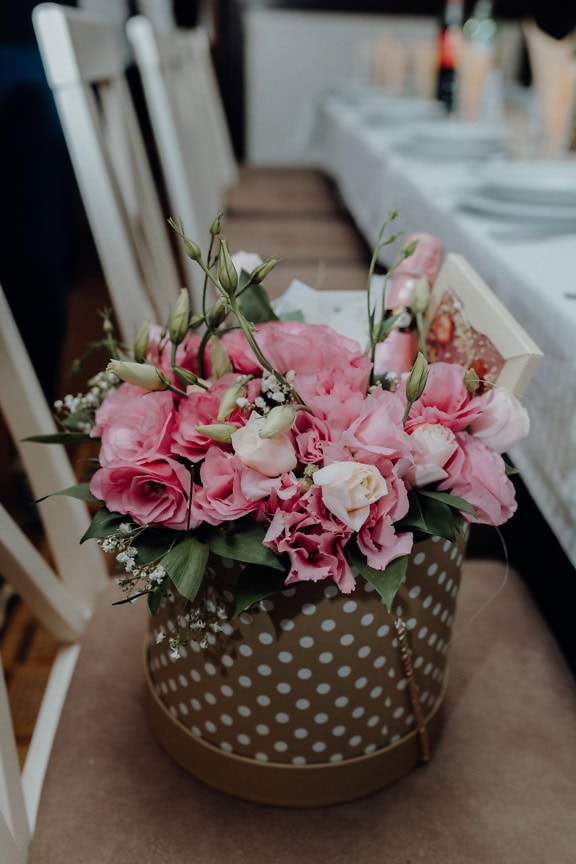 Ramo de flores rosas y regalo en caja de lunares, un regalo romántico de San Valentín