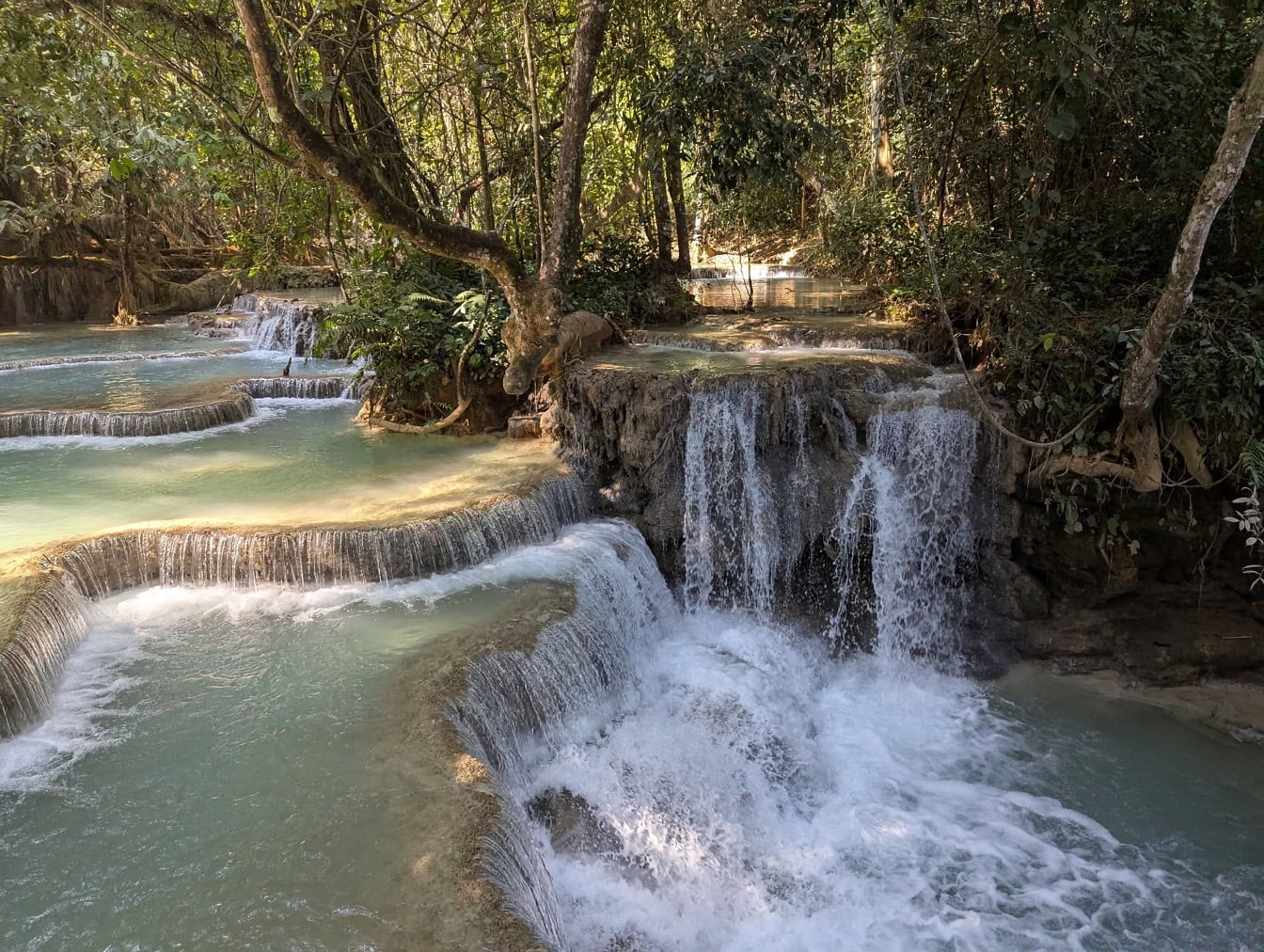 Vodopády Kuang Si s vodnými kaskádami s tyrkysovou vodou vodopád v lesoch, Luang Prabang, Laos