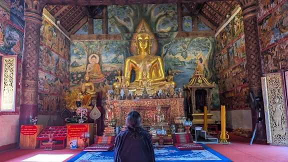 A large gold statue of Buddha, Wat Mai Suwannaphumaham monastery or Wat Mai or Wat May, a Buddhist temple or wat in Luang Prabang, Laos