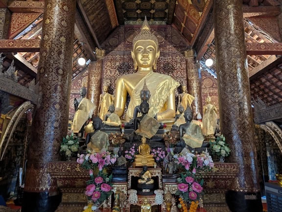 Giant statue of a Buddha in a central shrine hall of the Wat Xiengthong a Buddhist temple, Luang Prabang, Laos