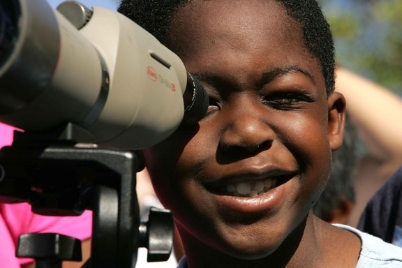 Afro American boy, face, child enjoying, lens, binocular