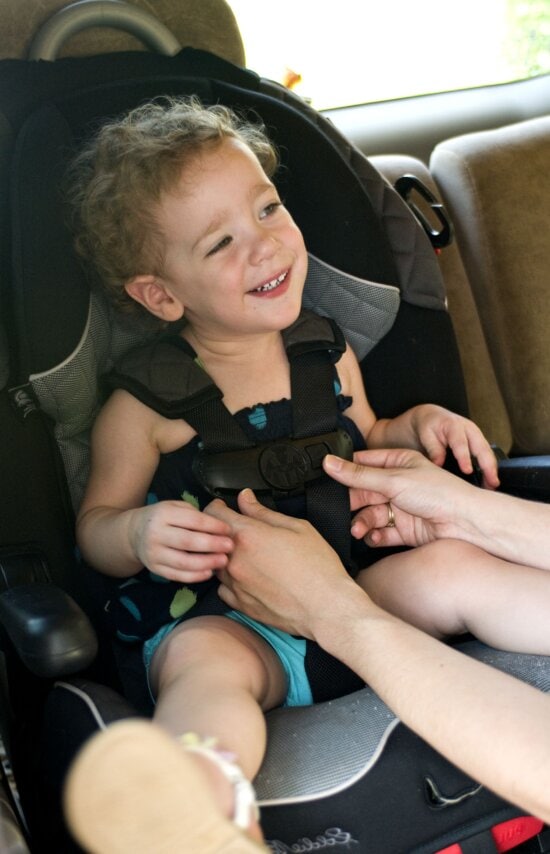 mother, securing, adjusting, daughter, car seat
