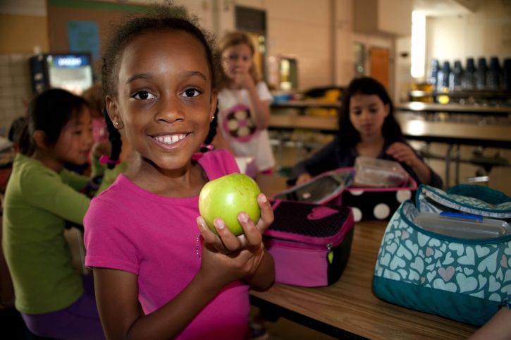 smile, young, African American, girl, holding, Granny Smith apple, hand