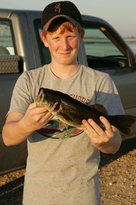 teenage boy, fishing, holding, bass, fish