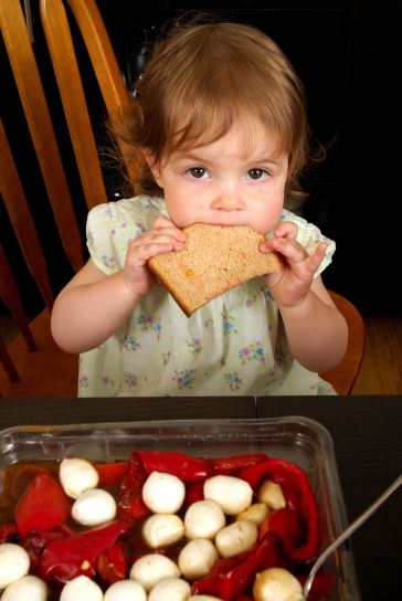 mladá dívka, sedící, večeře, stolu, jíst, řez, pšenice, chléb