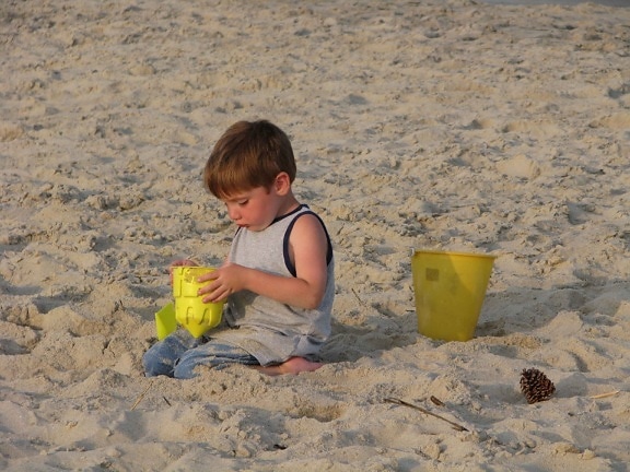 молодий хлопчик, будівлі, пісок, замок, пляж