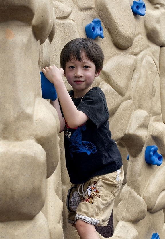 young boy, attempting, climb, fabricated, rock, wall