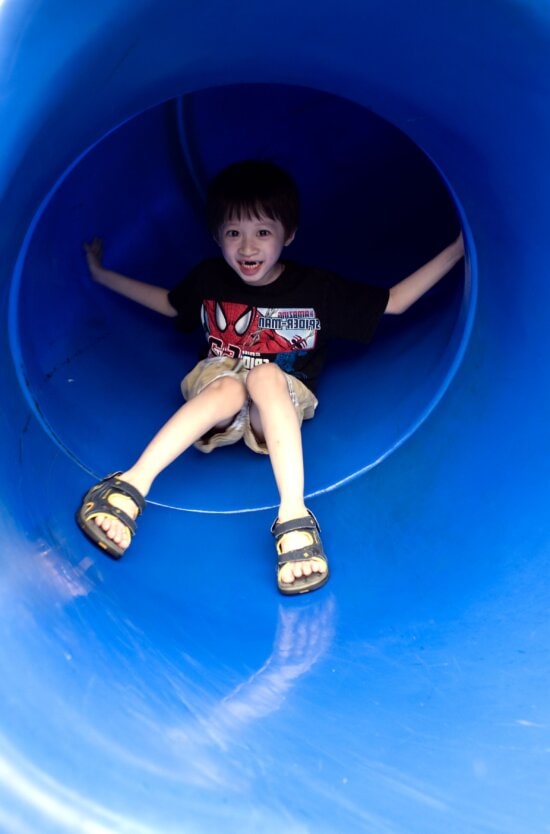 young boy, taking, trip, down, bright blue, slide, neighborhood, playground