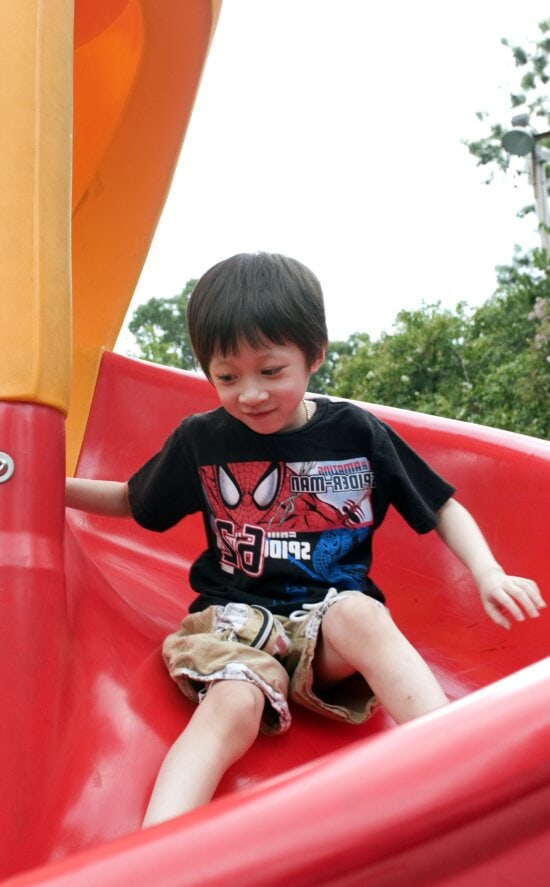 young boy, taking, trip, down, bright red, slide