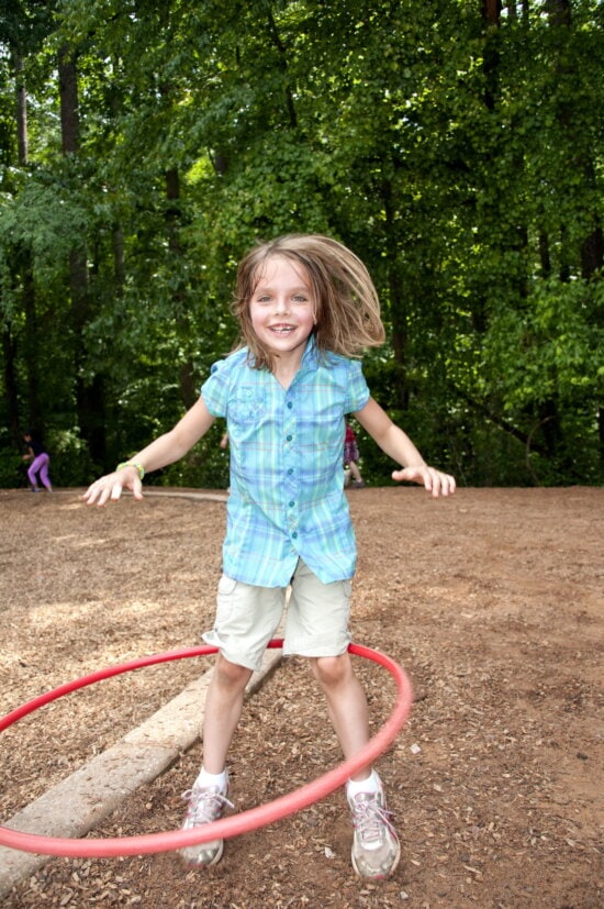 young girl, fun, enjoying, spinning, hula hoop, school yard