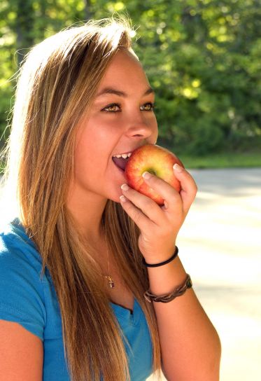 lijepa mlada žena jede, jabuka