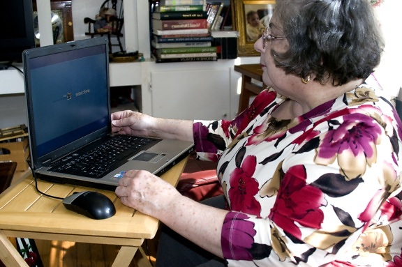 Mormor, sittande, liten, hopfällbar, bord, laptop, dator