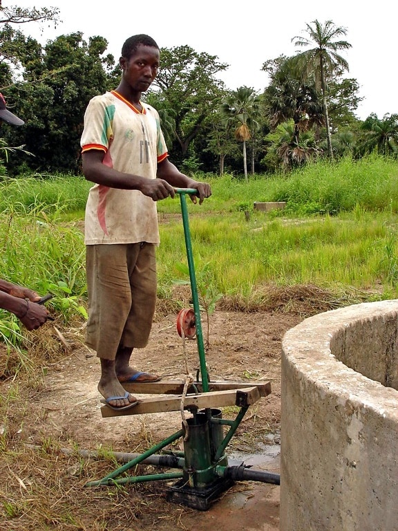 Senegalin, mies, töiden asennettu vesipumppu, auttaa viljelijöitä, kastella, maa