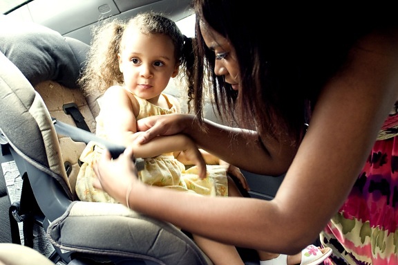 mother, securing, young, daughter, back, seat, car