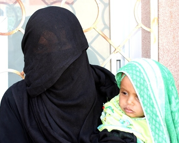 mother, young child, stand, outside, health care, facility, Yemen