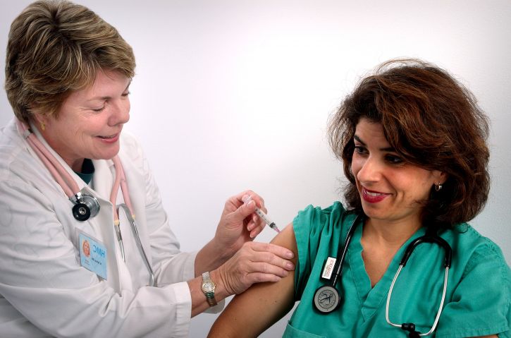 femmina adulta, sanitario, professionale, riceve, per via intramuscolare, la vaccinazione