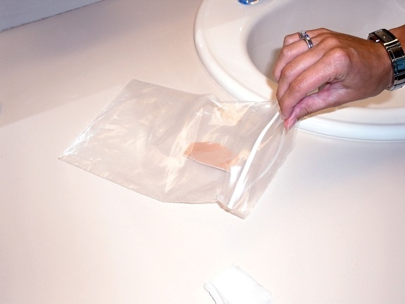 smallpox, vaccinee, shown, placing, dirty, waterproof, bandage, sealable, plastic, bag