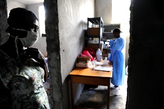 woman, stands, hallway, personnel, prepare, supplies, cholera, treatment, center