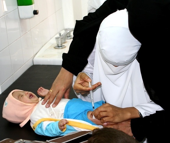 Yemen, female, doctor, vaccinates, child