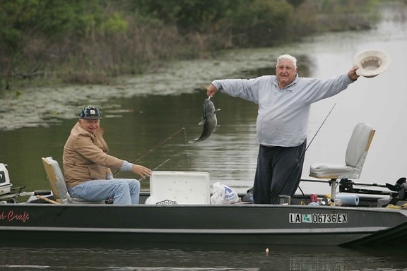 two, older men, enjoying, fishing boat, one, man, standing, raising, hat, fish, caught