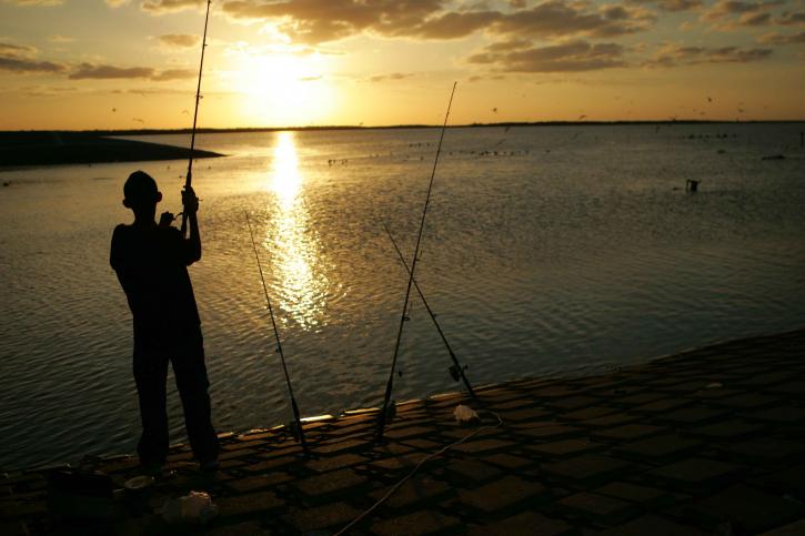 ung mann, står, fiske, solnedgang